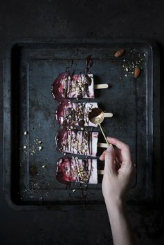 Creamy yogurt and cherry syrup popsicles with dark chocolate and salted roasted almonds