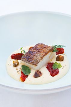 Pan-fried cod fillet with polenta mousse, anchovies, fried capers and candied tomatoes